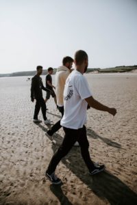 Group of men strolling on beach