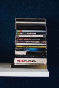 stack of books on white wooden shelf